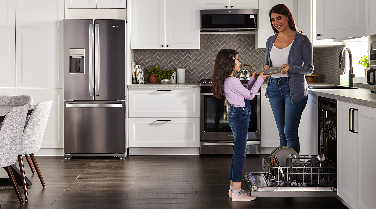 A woman and child standing beside an open dishwasher in a contemporary kitchen