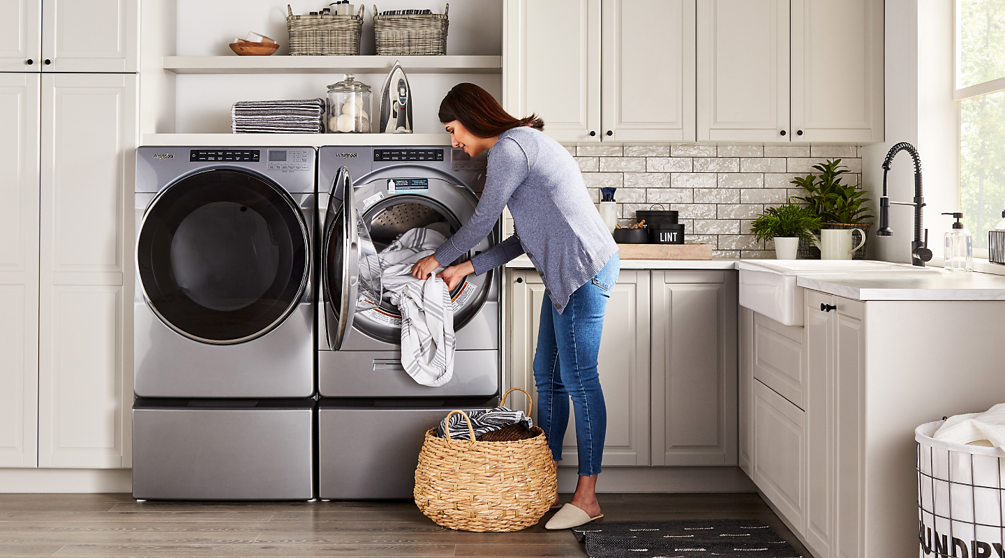 Woman loading laundry in a front-loading dryer