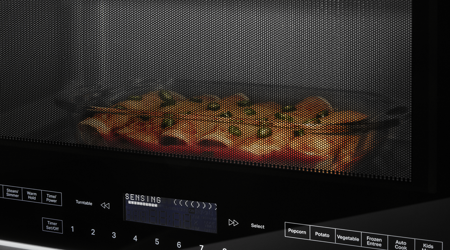 A closeup of enchiladas cooking in a Whirlpool® microwave.