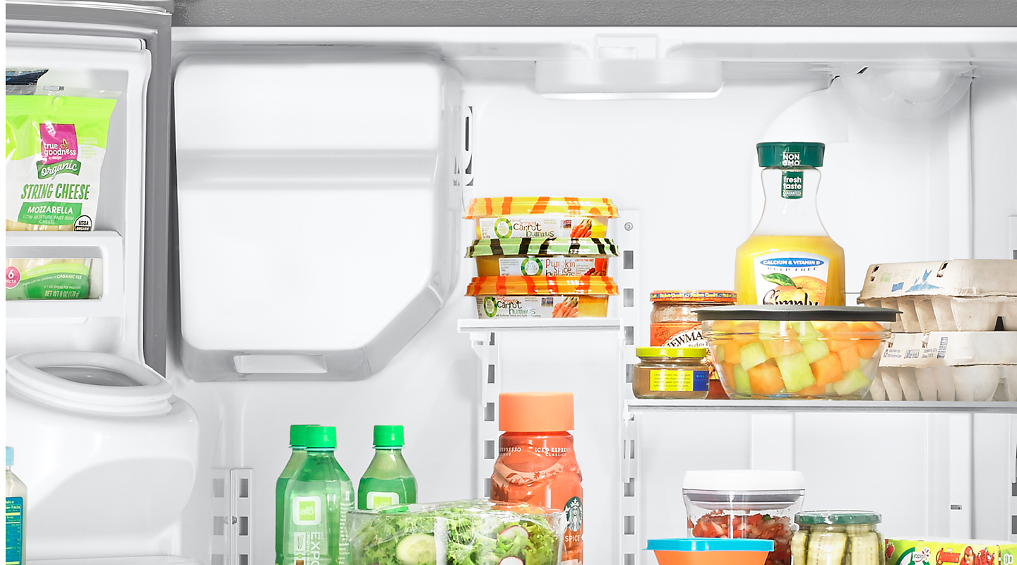 Various food items on the shelves and in the bins of a refrigerator