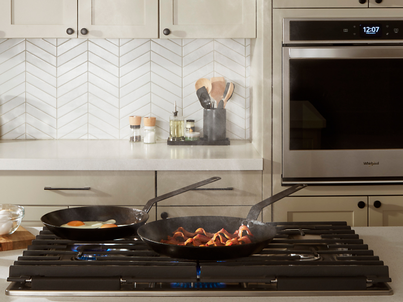 Pans cooking food on a Whirlpool® cooktop