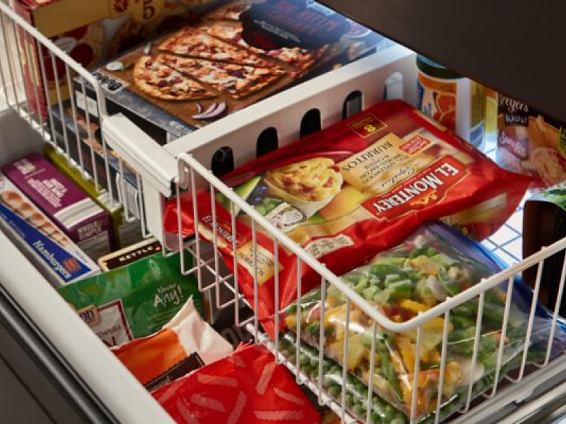 A bottom freezer refrigerator with frozen food