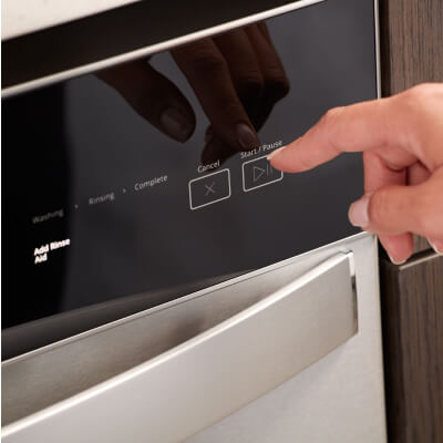 Person selecting a wash cycle on a Whirlpool® dishwasher