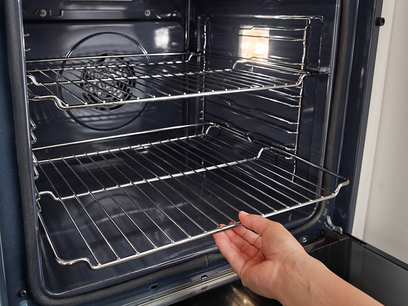 Person pulling out lower oven rack