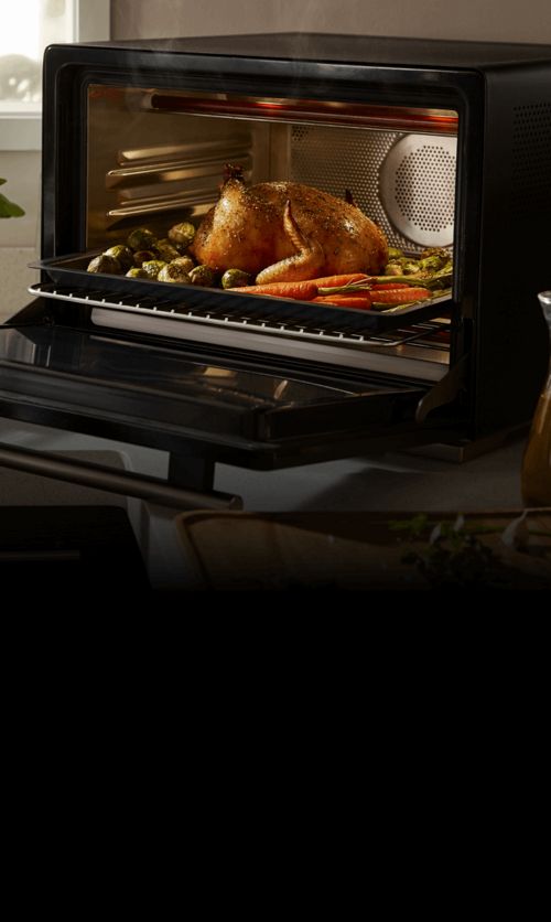 An open WLabs™ Smart Oven on a counter filled with cooked chicken and vegetables.