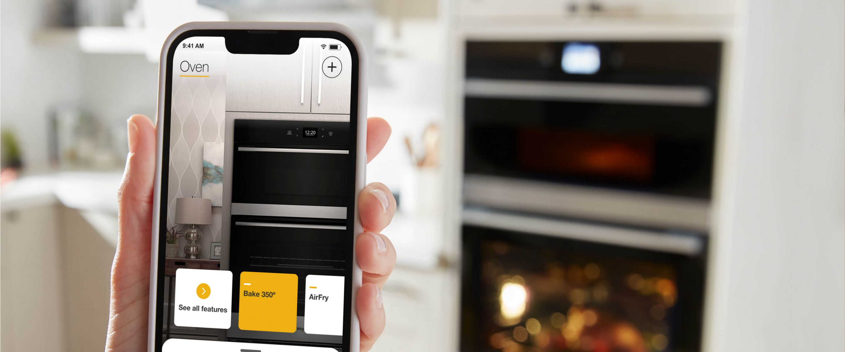 Closeup of a hand holding a smartphone showing a cooking mode screen in the Whirlpool® App