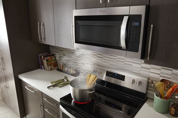 An over-the-range microwave above a working stovetop.