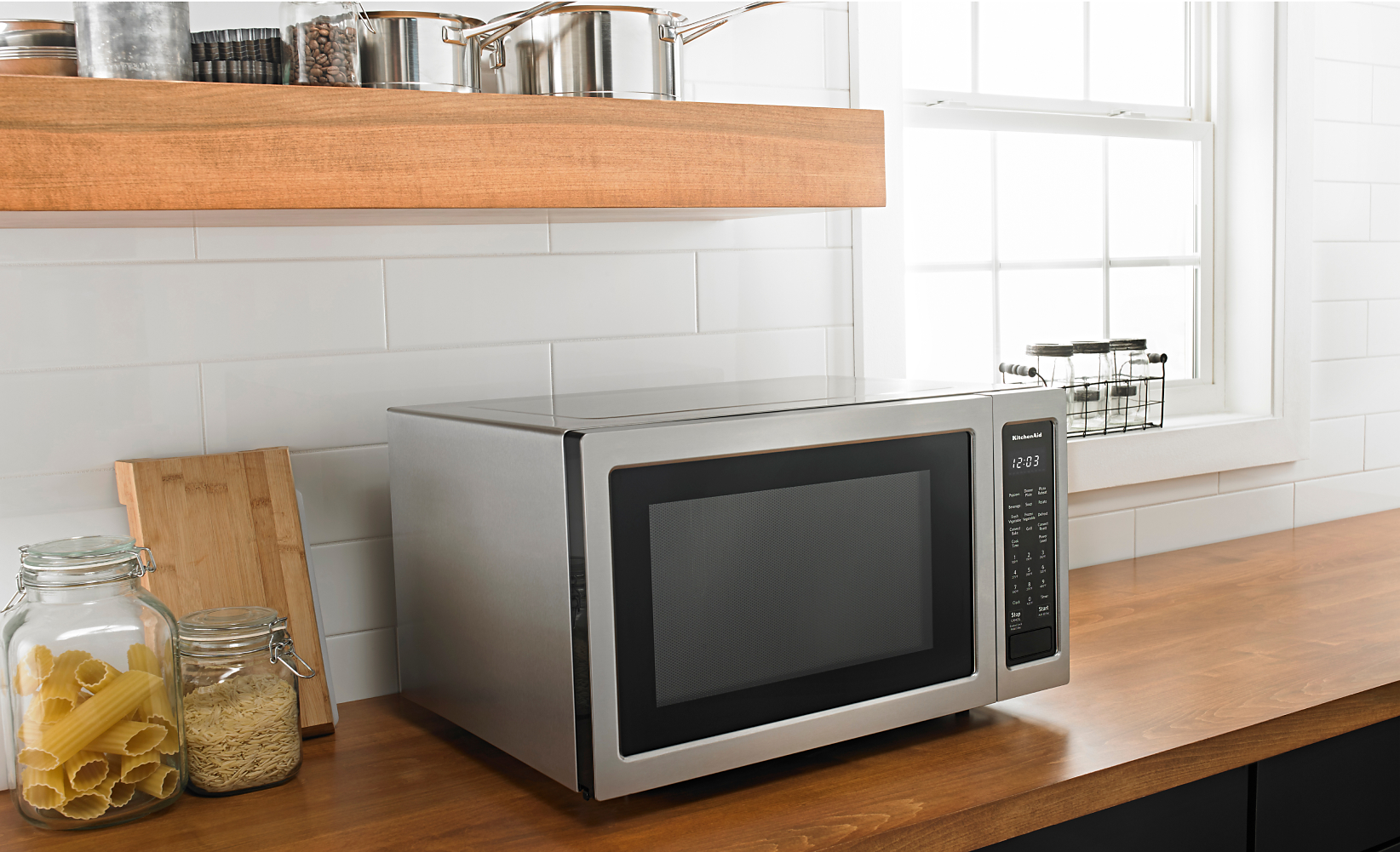 A countertop microwave resting on top of a wood counter.